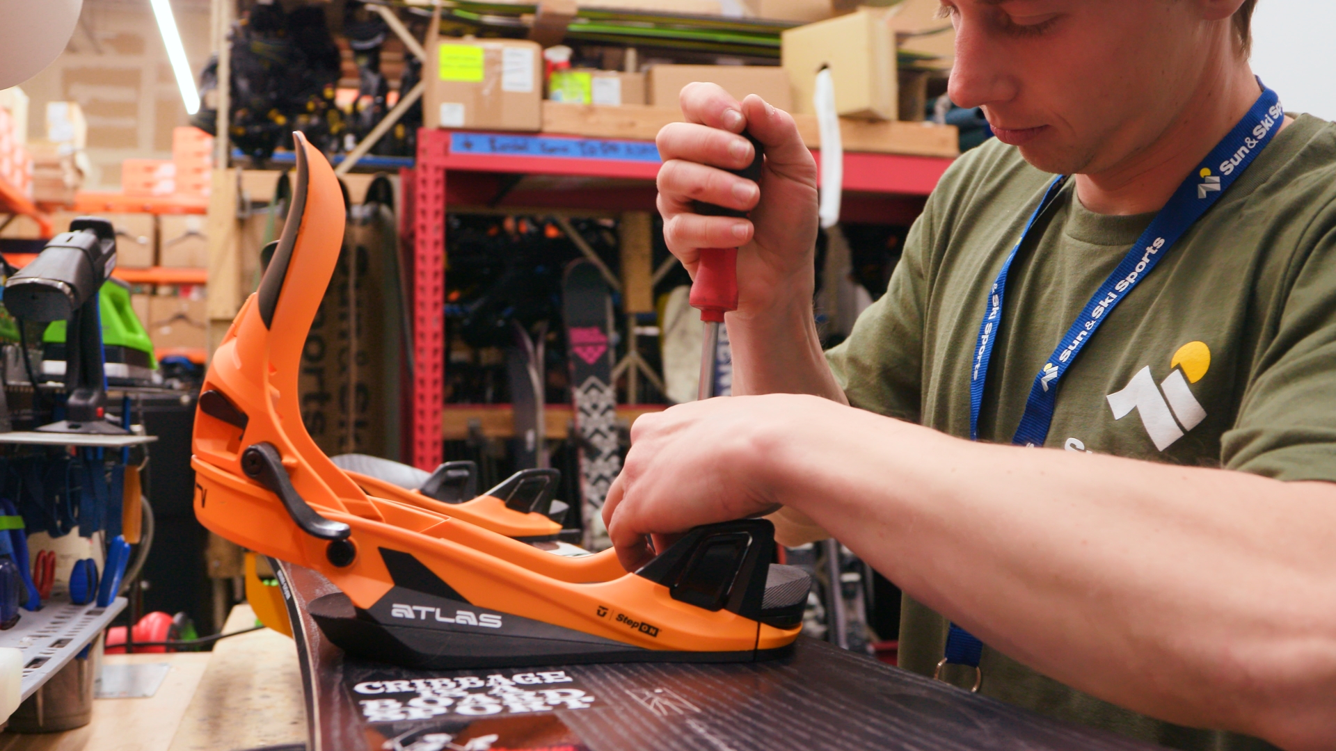 An outdoor expert performing repairs on a snowboard